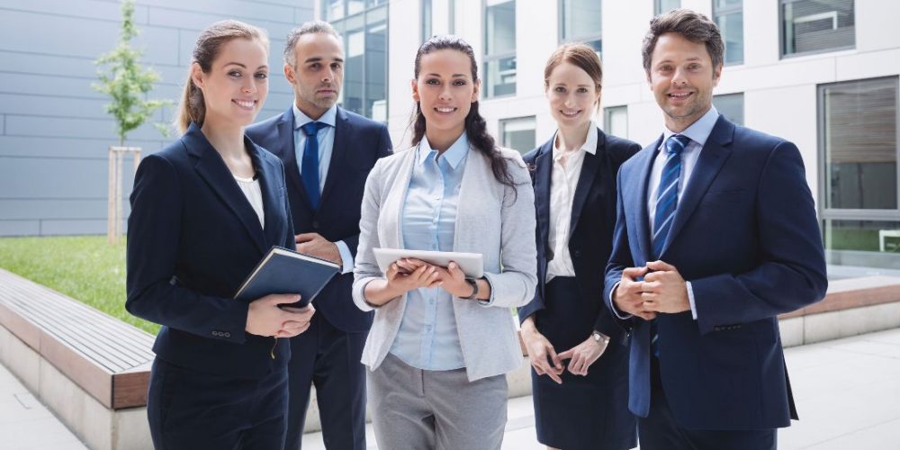 Portrait of confident businesspeople standing outside office building